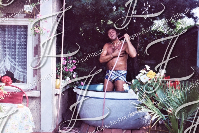 Mann duscht freudig im Garten, 1975